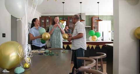 Senior Friends Joyfully Preparing Home for Festive Celebration