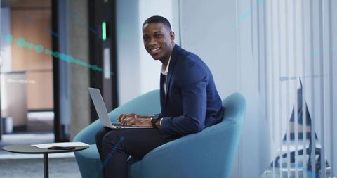 Young professional man typing on laptop in modern office lounge