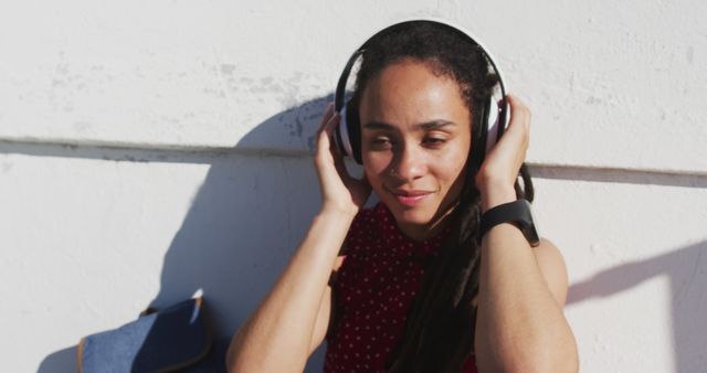 Young Woman with Headphones Enjoying Music Outdoors in Sunlight - Download Free Stock Images Pikwizard.com