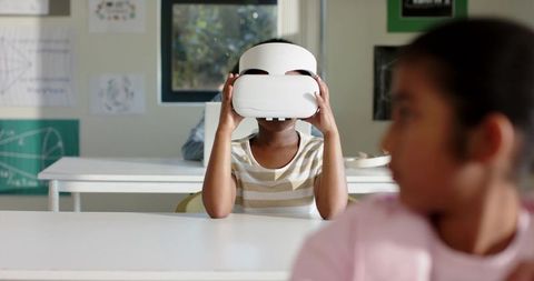African American Student Using VR Headset in Classroom with Classmates Watching and Learning