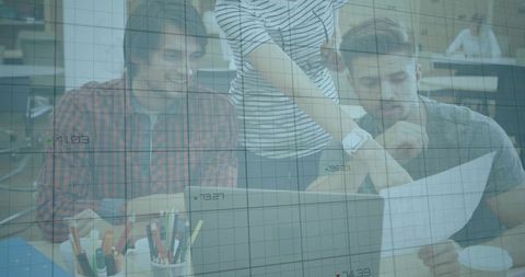 Young professionals collaborating over laptop and documents with digital data grid overlay