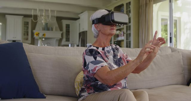 Senior Woman Using Virtual Reality Headset on Sofa in Living Room - Download Free Stock Images Pikwizard.com