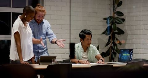 Diverse team collaborating on evening office project