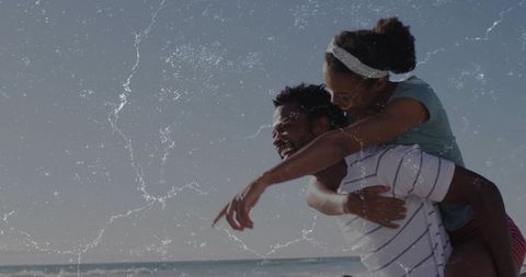 Sunlit beach couple enjoying piggyback ride with vintage film grain and playful laughter