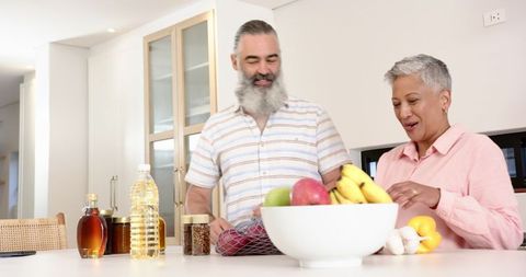Senior Couple in Modern Kitchen Preparing Healthy Fruits