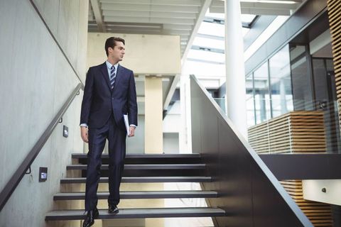 Confident Businessman Descending Modern Office Staircase