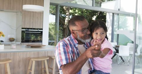 Grandfather Teaching Granddaughter in Modern Kitchen