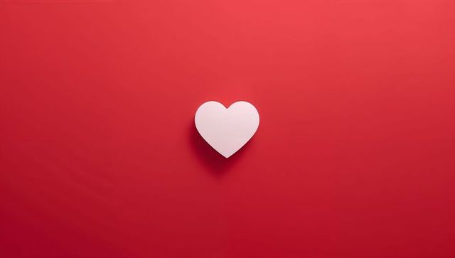 Floating white heart casting soft shadow on minimal red field for valentine campaigns
