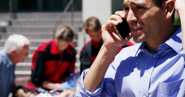 Man On Phone Calling Emergency While Paramedics Assist Unseen Victim - Download Free Stock Images Pikwizard.com