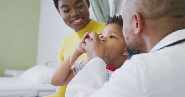 African american male doctor examining child patient at hospital. Medicine, healthcare, lifestyle and hospital concept.