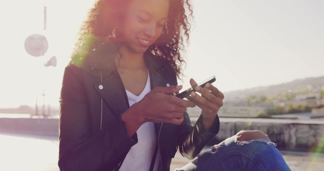 Smiling Woman in Leather Jacket Using Smartphone Outdoors - Download Free Stock Images Pikwizard.com