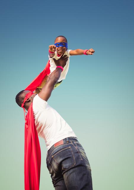 Father lifting child dressed in superhero costume outdoors. Perfect for themes related to family bonding, imaginative play, parenting, and childhood fun. Ideal for use in advertisements, blogs, and articles about family activities, parenting tips, and children's creativity.
