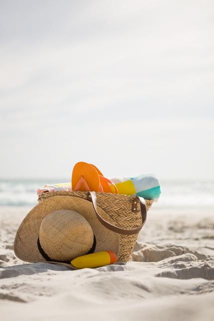Bag with beach accessories kept on sand at beach