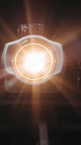 Vertical video capturing studio luminaire emitting warm circular beam and lens flare