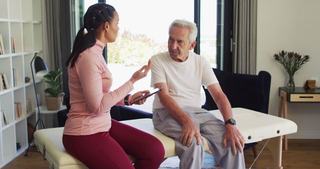 Senior Man Receiving Consultation from Physical Therapist at Home - Download Free Stock Images Pikwizard.com