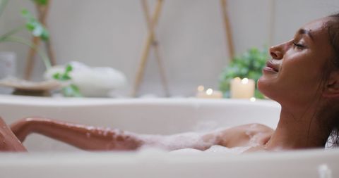 Biracial woman relaxing in bathtub for self-care at home