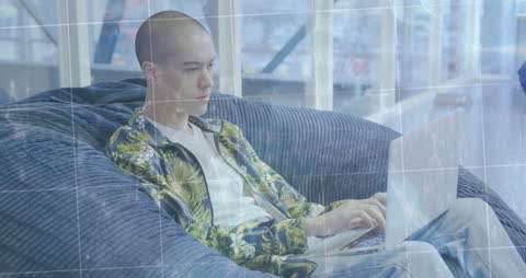 Young Man Using Laptop in Tech-Driven Workspace