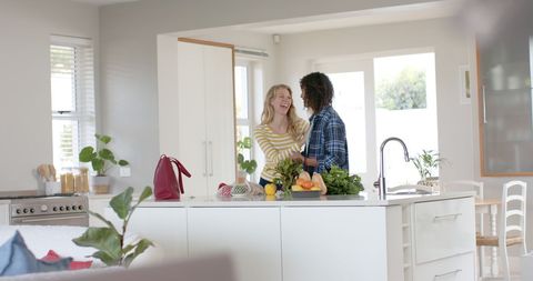 Diverse Couple Embracing While Unpacking Groceries in Home Kitchen - Download Free Stock Images Pikwizard.com