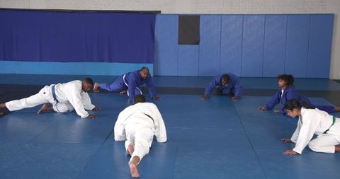Martial Arts Class Practicing Stretches in Dojo Setting