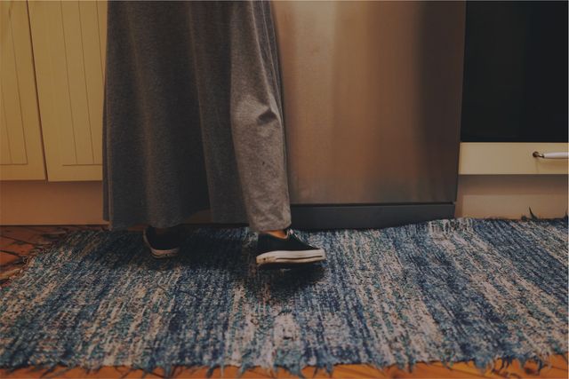 Person Right Foot Wearing Black Shoe On Blue Rug In Kitchen - Download Free Stock Images Pikwizard.com