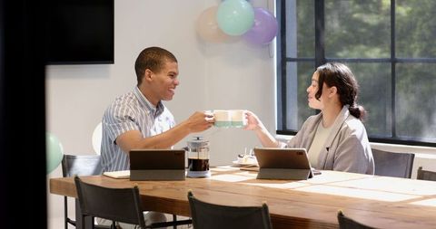 Co-workers celebrating with coffee and cake in office