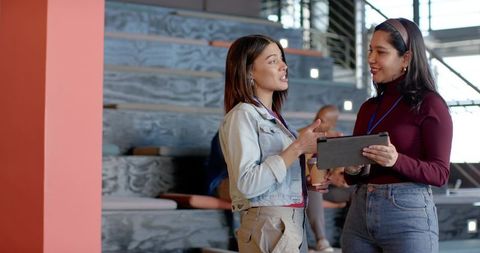 Diverse Colleagues Discussing Project on Tablet in Bright Coworking Space