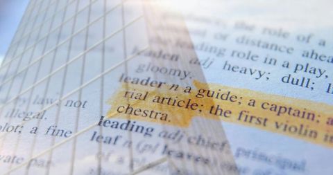 Highlighting leader dictionary entry reflecting glass skyscraper, leadership concept