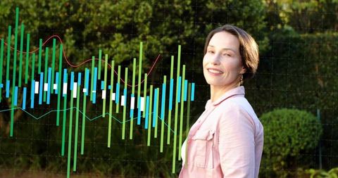 Standing woman turning toward camera in garden showcasing colorful financial chart overlay