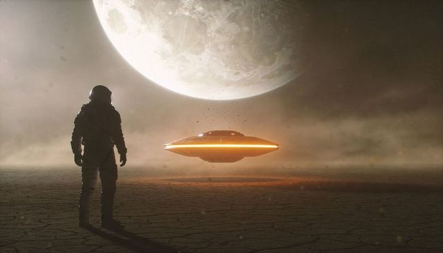 Astronaut facing hovering ufo on cracked alien plain under giant moon