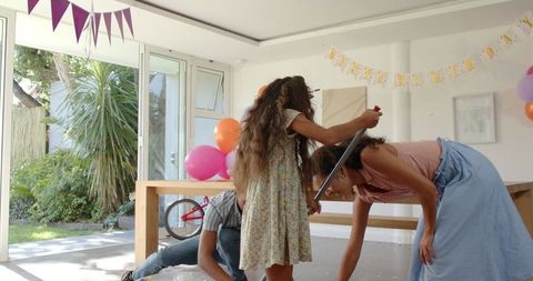 Family cleans up celebration with festive banners and colorful balloons