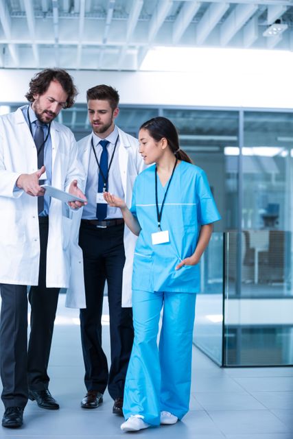 Doctor holding digital tablet having a discussion with colleagues in hospital