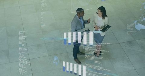 Discussing data visualization in corporate lobby with charts and analytics overlay