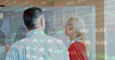 Business professionals analyzing financial stokes in modern office setting