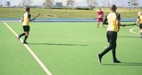 Field hockey players in match action on artificial turf