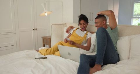 Couple Enjoying Online Shopping Together in Cozy Bedroom