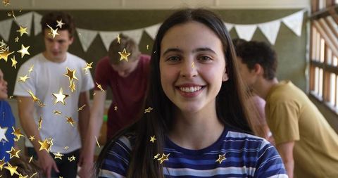 Smiling teenage girl leading collaborative classroom teamwork with peers, pennant banners, daylight
