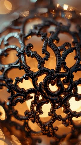 Rotating close-up on metal filigree sphere revealing ornate pattern and warm bokeh