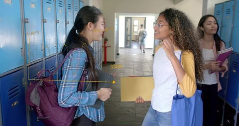 Teen students chatting at blue lockers with backpacks and folders, casual campus life
