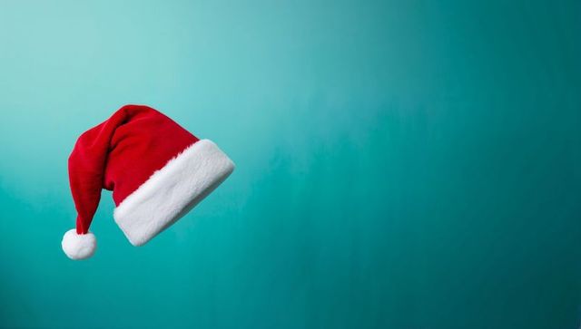 Floating Santa Hat on Teal Background for Holiday Promotions and Greeting Cards