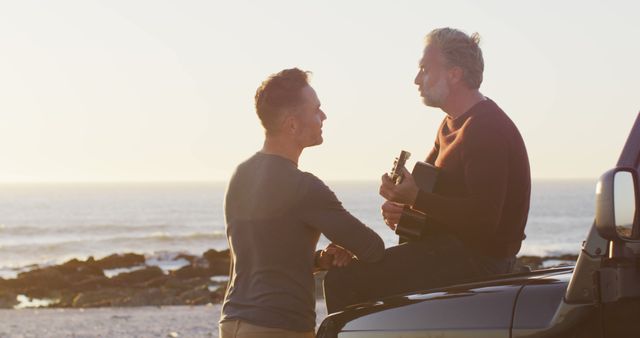 Mature Couple Enjoying Guitar Music by Ocean During Sunset - Download Free Stock Images Pikwizard.com