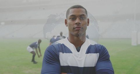 Confident rugby player posing with crossed arms on stadium pitch with globe overlay