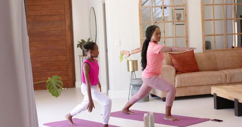 African american mother daughter practicing yoga together at home for wellness and bonding