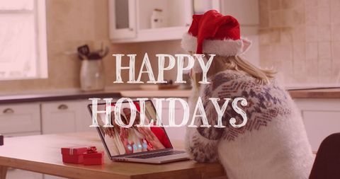 Happy holidays greeting with woman video calling using laptop