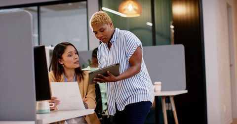 Diverse Colleagues Collaborating with Tablet and Documents in Modern Office