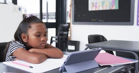 Young student engaged in learning on tablet in classroom