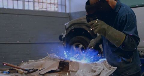 Experienced Welder Joining Metal Parts in Repair Shop with Precision