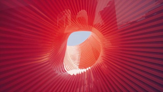 Abstract red sculptural spiral with architectural fins
