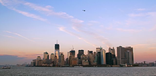 Evening Skyline of Manhattan with Flying Helicopter and Cruise Ship on River - Download Free Stock Photos Pikwizard.com