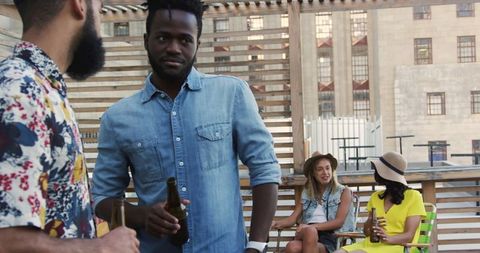 Friends Enjoying Rooftop Party with Drinks and Conversations