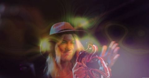 Female Musician Playing Tambourine with Swirling Stage Lighting